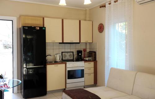 a kitchen with a black refrigerator and a stove at Sunny Family Apartment in Iraklitsa