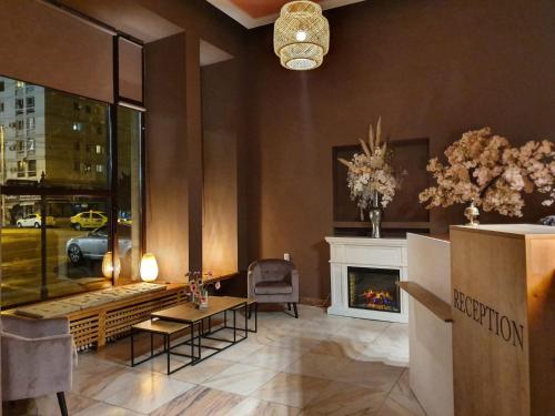 a living room with a fireplace and a table at Hotel Continental City Center in Iaşi