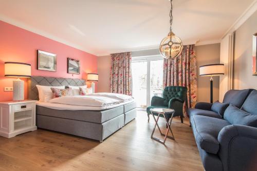 a bedroom with a bed and a couch at Hotel Norderriff in Langeoog