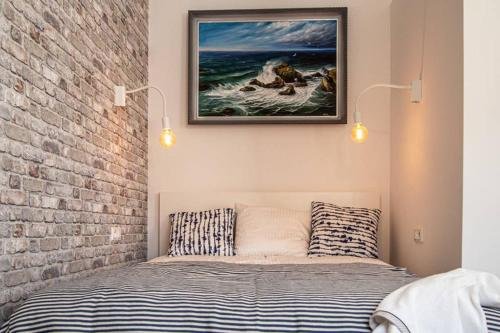 a bedroom with a bed and a painting on the wall at O & O Studio in Kraków