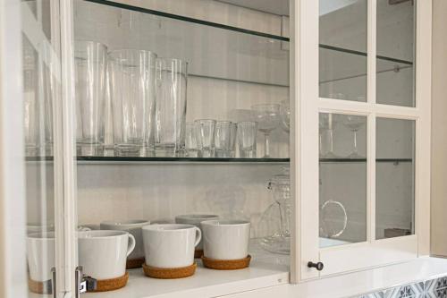 a cabinet filled with glasses and bowls on a shelf at O & O Studio in Kraków