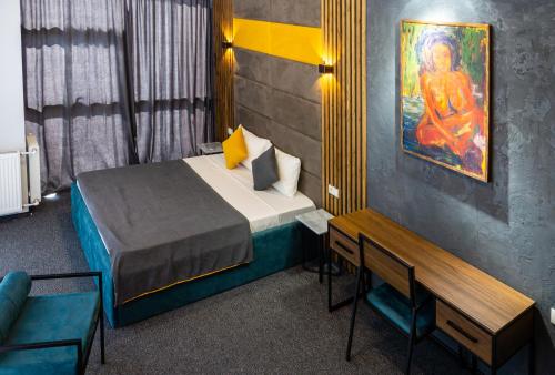 提比里斯的住宿－BG Palace Hotel，卧室配有一张床,墙上挂有绘画作品