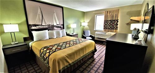 a hotel room with a large bed and a desk at Economy 7 Inn Chesapeake - Portsmouth in Chesapeake