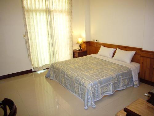 a bedroom with a bed and a window at Feng Lin Homestay in Shuili