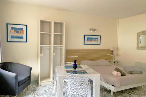 une chambre avec un lit, une table et une chaise dans l'établissement A l'Ancre Bleue, au Tréport