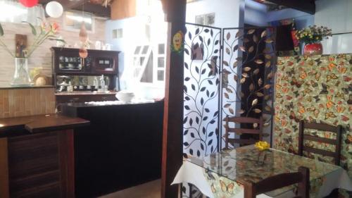 een eetkamer met een glazen tafel en een bar bij Pousada Luar e Serenata in Conservatória