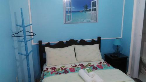 a bedroom with a bed with a blue wall at Pousada Luar e Serenata in Conservatória
