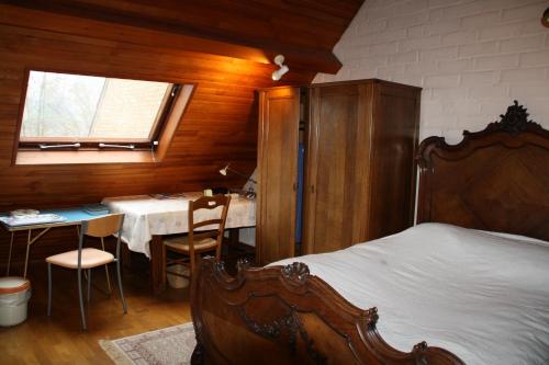 een slaapkamer met een bed, een tafel en een raam bij B&BAcacias in Croix