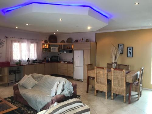 Bilene Dream House 1 في Vila Praia Do Bilene: مطبخ وغرفة معيشة مع ضوء أزرق