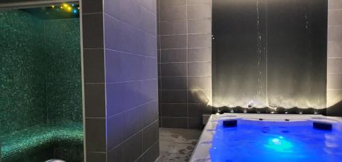 a bathroom with a blue tub and a shower at Le Castelet in Le Mont-Dore