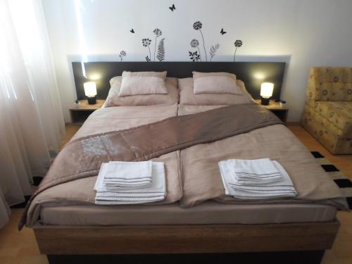 a bedroom with a large bed with two towels on it at merRelax Apartman in Miskolc