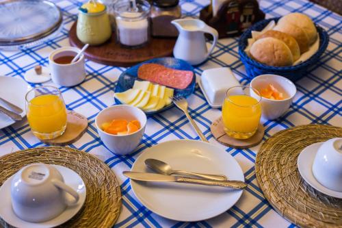 uma mesa azul e branca com pratos e chávenas de sumo de laranja em Hospedaje El Roble, Puerto Varas em Puerto Varas