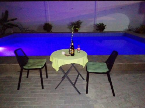 a table with two chairs and a bottle of wine at Hostal Villa Brisa in Ballenita