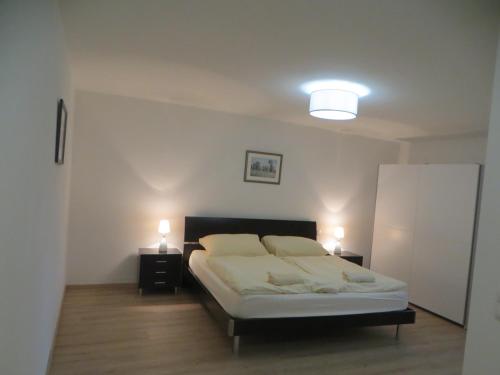 a bedroom with a bed with two lights on it at Premium City Apartment Amadeus in Salzburg