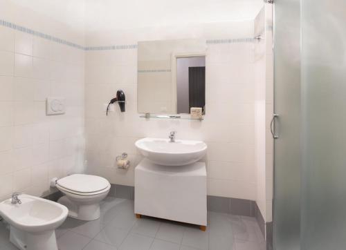 a white bathroom with a sink and a toilet at Al Borgo in Sarzana