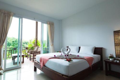 a bedroom with a large bed and a balcony at Nakakiri Resort & Spa in Hin Dat