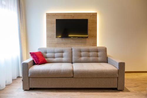 a couch with a red pillow in a living room at Gasthof Krone Ochsenfeld in Ochsenfeld