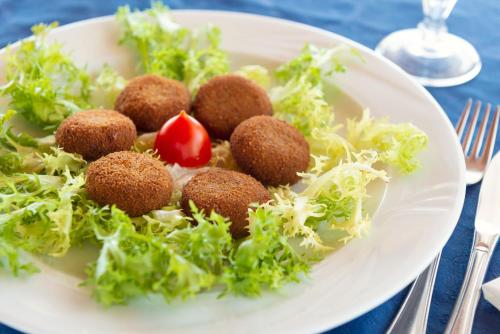 a plate of food with a salad on a table at Eunymos Panarea in Panarea