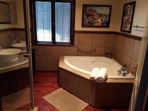 a bathroom with a tub and a sink at Khumbula Lodge in Underberg