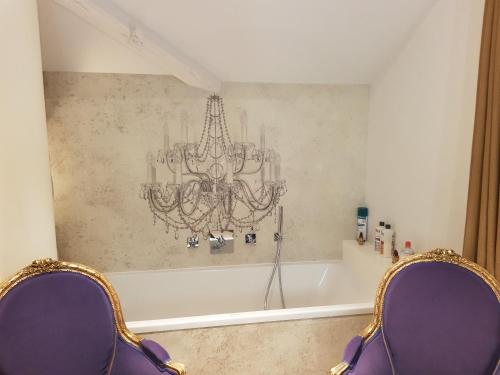 e bagno con lampadario pendente e vasca. di chambre d'hôte Croix-Rousse a Lione