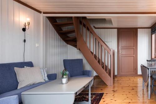a living room with a blue couch and a staircase at Håholmen - by Classic Norway Hotels in Karvåg