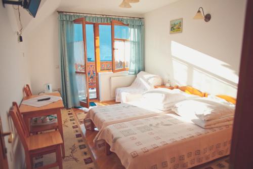 a bedroom with two beds and a table and window at Willa Dutka in Szczawnica