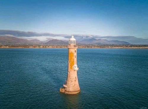 a lighthouse in the middle of a body of water at Greencastle B&B in Kilkeel
