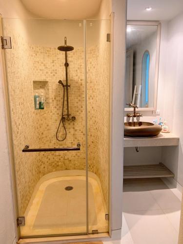 a shower in a bathroom with a sink at Chelona huahin beachfront condominium in Khao Tao