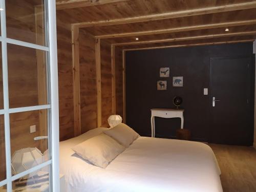 a bedroom with a white bed and a black wall at La Sapinière St Lary Soulan in Saint-Lary-Soulan