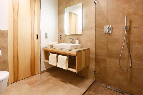 een badkamer met een wastafel en een douche bij Landgasthof Geser in Sarching