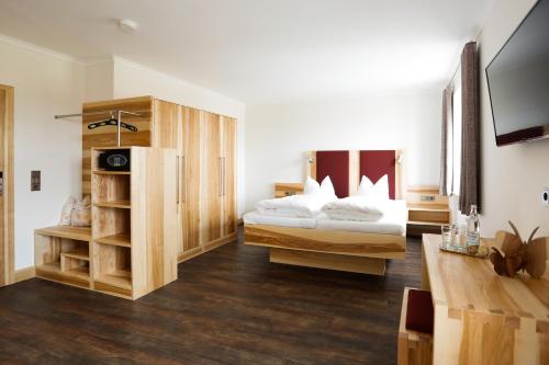 a hotel room with two beds and a tv at Landgasthof Geser in Sarching