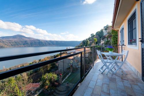 a balcony with a table and a view of the water at Il bianconido in Castel Gandolfo