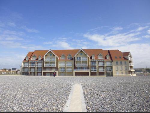 a large apartment building with a road in front of it at APPARTEMENT FACE A LA MER 6 PERSONNES in Cayeux-sur-Mer