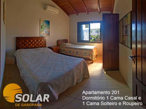 a bedroom with two beds and a window at Solar de Garopaba in Garopaba