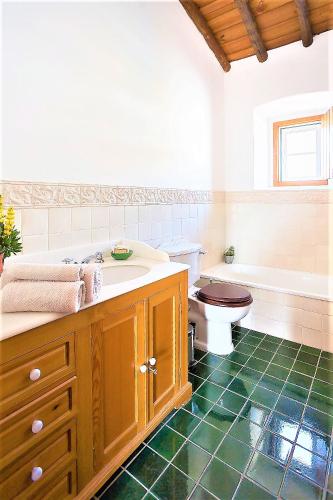 a bathroom with a sink and a toilet and a tub at Monte Papa Toucinho in Estremoz