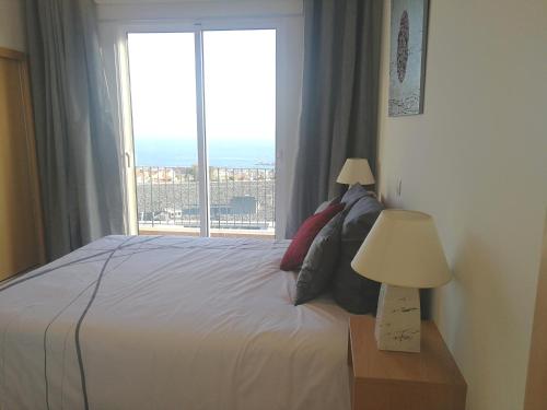 a bedroom with a bed with a large window at Casa do Imaculado in Funchal