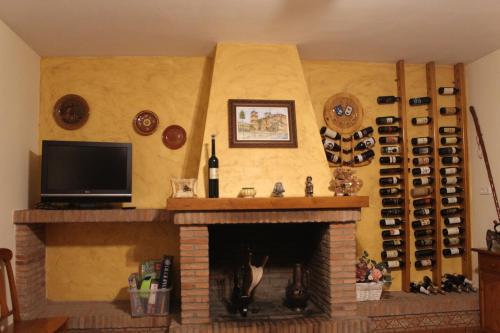 a living room with a fireplace with a tv and a tv at CASA RURAL BUENA VENTURA in Villanueva de los Infantes