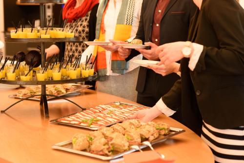 a group of people standing around a table with food at Hohenwart Forum in Pforzheim