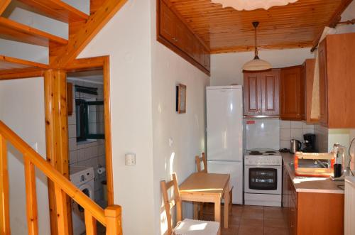 een keuken met een witte koelkast en houten kasten bij Terra Lemnia B in Repanídhion