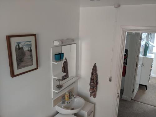 a white bathroom with a sink and a mirror at Namastay-Central Glastonbury in Glastonbury
