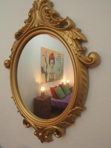 a mirror hanging on a wall with a bedroom at The Portuguese Element in Faro