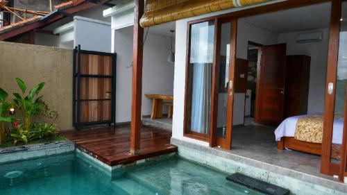 a house with a swimming pool and a bedroom at Abinawa Hill in Lovina