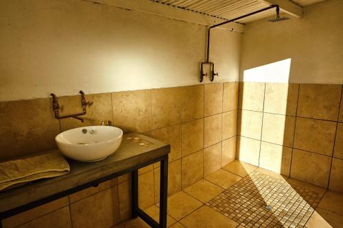 a bathroom with a white sink on a counter at ZuriCamp - Campsite Halishi in Tsumeb
