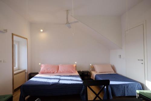 sypialnia z 2 łóżkami z niebieską pościelą i różowymi poduszkami w obiekcie Il Brigantino w mieście Cori