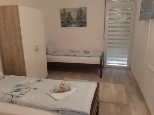 sypialnia z 2 łóżkami i lalką na ręczniku w obiekcie Apartman Amela w mieście Mostar