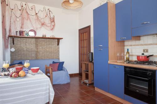 a kitchen with blue cabinets and a table with food on it at Casa al MARE CON SPLENDIDA VISTA SUL MARE in Petrosino