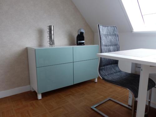 une commode blanche, un bureau et une chaise dans l'établissement AGREABLE STUDIO LUMINEUX COEUR VILLE PORNICHET, à Pornichet