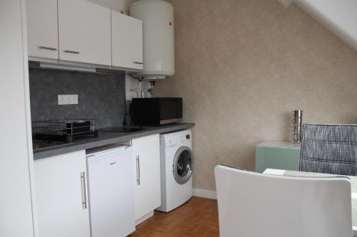 une cuisine avec des armoires blanches et une laveuse et une sécheuse dans l'établissement AGREABLE STUDIO LUMINEUX COEUR VILLE PORNICHET, à Pornichet