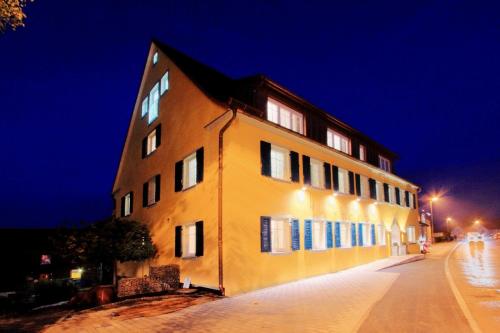 a yellow building on a street at night at Klozbücher - Das Landhotel in Ellwangen