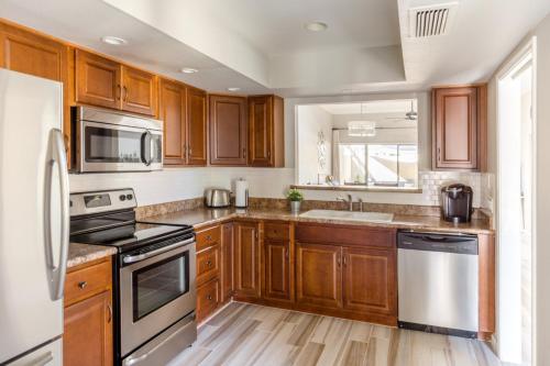 a kitchen with wooden cabinets and stainless steel appliances at Central Phoenix Townhome in Phoenix